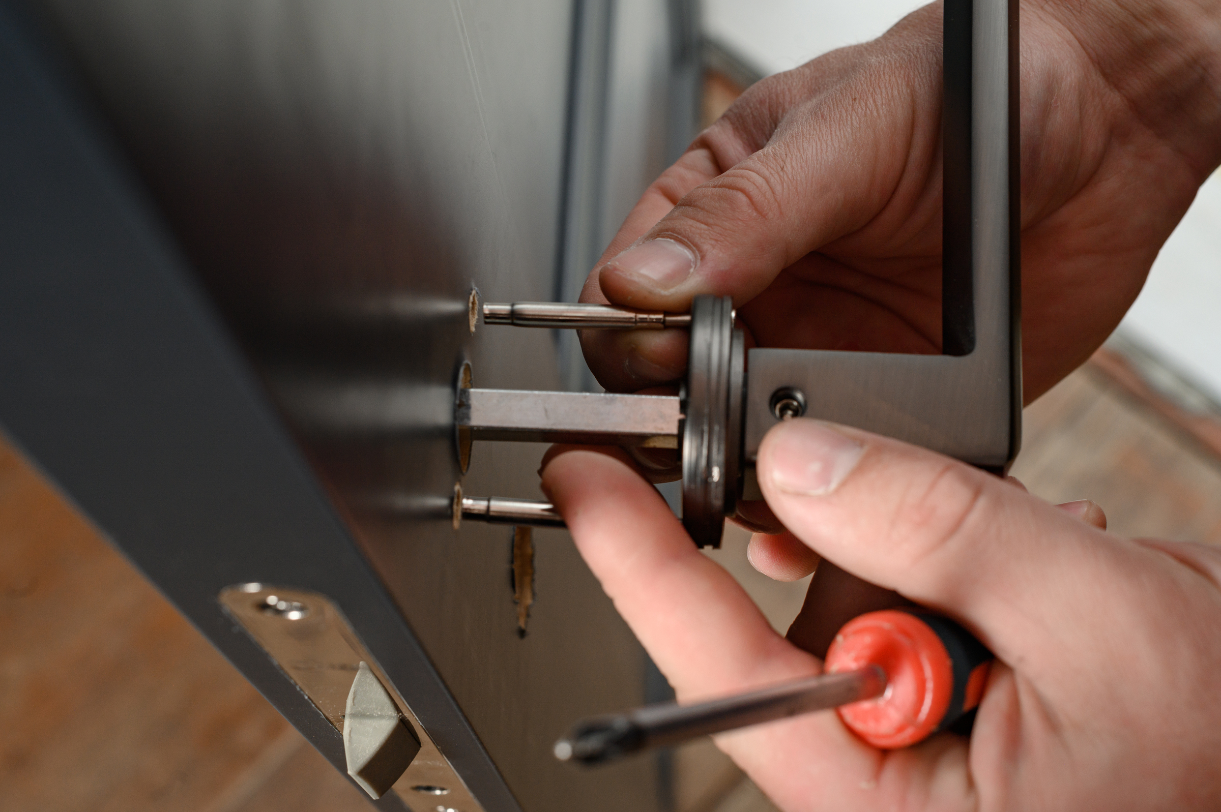 A man installs a doorknob in a door, carpentry at home. Cerrajeria